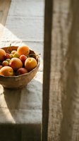 Wooden bowl filled with fresh apricots and plums on linen fabric in natural sunlight, ideal for food styling, culinary blogs, and organic produce marketing.