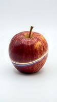 Red apple with glowing light band wrapped around it on white background, isolated fruit for health, nutrition, wellness and organic food design projects.