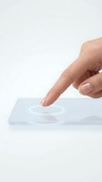 Hand touching transparent glass surface with circular ripple effect on white background for technology and interface design concepts.