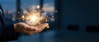 Businessman holding glowing light bulb with sparkling particles, representing innovation, ideas, and creative solutions for business growth and technology concepts.