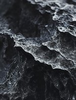 Abstract macro photography of crystalline ice formations creating dramatic shadows and light patterns on dark background, revealing intricate natural textures.