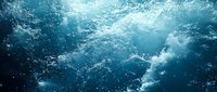 Powerful ocean waves creating dynamic turquoise water surface with white foam and bubbles, captured from underwater perspective.
