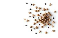 Scattered coriander and black peppercorns on white background, overhead view. Aromatic spices composition with copy space for culinary and food design projects.