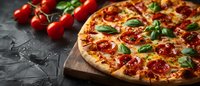 Fresh homemade pepperoni pizza with melted cheese, basil leaves and cherry tomatoes on wooden cutting board against dark background. For menu or food delivery.