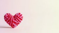 Pink yarn heart shape on soft gradient background for Valentine's Day crafts and romantic decorations.