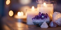 Amethyst crystals and healing stones arranged with glowing candles creating peaceful meditation atmosphere for spiritual wellness and relaxation practices.