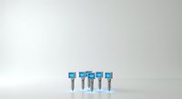 Isolated blue syringe needles with medical labels arranged in a row on white background, suitable for healthcare, pharmaceutical, and medical education design projects.