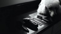 Standard poodle with white fluffy coat playing grand piano keys in black and white studio setting, suitable for music education, pet talent, and creative animal concepts.