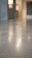 Blurred modern interior with polished concrete floor and warm lighting creating soft bokeh effect for contemporary architectural backgrounds.