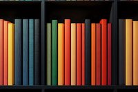 Colorful book spines arranged in rainbow order on dark wooden shelf, creating vibrant gradient pattern from yellow through blue, green, orange to red tones.