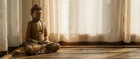 Golden Buddha statue in meditation pose on wooden floor with soft sunlight streaming through curtains creating peaceful zen atmosphere for mindfulness practice.