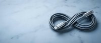 Black ethernet cable forming infinity symbol on marble surface representing endless connectivity and network solutions for technology concepts.