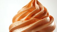 Creamy caramel soft serve ice cream swirl with delicate water droplets on smooth surface, macro photography showing texture and glossy finish.