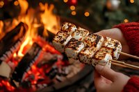 Roasted marshmallows on skewers by cozy fireplace with warm bokeh lights creating festive winter atmosphere for holiday gatherings and comfort food moments.