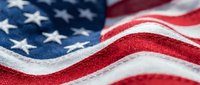 American flag with stars and stripes in red white and blue colors showing patriotic symbol of United States waving in close-up detail view.