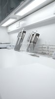 Modern white kitchen counter with knife block and wire storage basket under LED lighting for culinary design and home interior concepts.