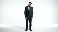 Middle-aged male professional with dark hair and beard wearing formal black suit and tie against white background for corporate and business applications.