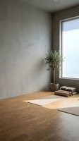 Minimalist yoga studio with mat on wooden floor, potted plant by window, neutral walls creating serene meditation space for wellness and mindfulness practice.