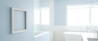 Modern bright bathroom interior with white bathtub, blank frame on blue wall, natural light from windows, clean minimalist design.