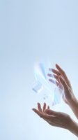 Hands reaching toward holographic digital elements with iridescent light effects on soft gradient background for futuristic technology concepts.
