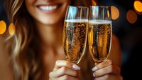 Smiling young woman holding two sparkling champagne flutes with golden bubbles against blurred bokeh lights background, celebrating special occasion.