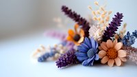 Delicate arrangement of dried flowers in purple, blue and peach tones featuring lavender sprigs, daisy-like blooms and preserved botanicals on soft neutral background.
