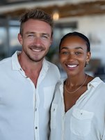 Happy diverse couple smiling together in modern office environment wearing casual white shirts for business teamwork and partnership concepts.