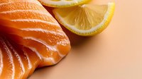 Fresh salmon fillet with lemon slice on neutral background, suitable for food photography, culinary blogs, restaurant menus, and healthy eating content.