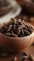 Aromatic cardamom pods and black peppercorns in wooden bowl, macro view of spices used in cooking, baking, and traditional medicine.