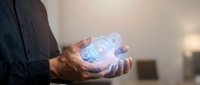 Professional businessman holding glowing digital holographic sphere with futuristic interface elements in modern office environment for technology presentations.