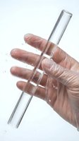 Hand in protective glove holding glass test tube with water drops on white background for laboratory research and scientific experiments.
