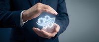 Businessman in dark suit holding glowing eye symbol between hands, representing vision, insight, and digital technology for business and innovation concepts.