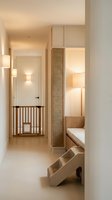 Modern minimalist interior hallway with warm lighting and wooden staircase featuring clean lines and neutral tones for contemporary home design.