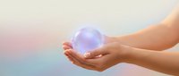 Hands gently holding glowing purple crystal sphere with magical light effects against soft pastel gradient background for spiritual healing concepts.
