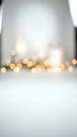 Soft blurred golden bokeh lights on white background creating dreamy atmosphere for holiday celebrations and festive decorations.