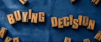 Wooden letters spelling buying decision on blue fabric background, representing consumer choice and purchasing behavior for retail and marketing concepts.