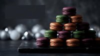 Colorful French macarons stacked in pyramid on dark wooden surface with blurred Christmas ornaments creating festive holiday dessert display for bakery marketing.