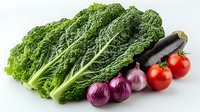 Fresh organic vegetables arranged in row including green savoy cabbage leaves, purple onions, black eggplant, and ripe tomatoes on white background for healthy eating concept.