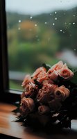 Pink roses bouquet on windowsill with raindrops creating romantic atmosphere for wedding anniversary Valentine's Day home decor and floral arrangements.