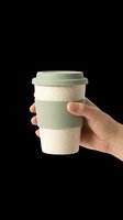 Reusable eco-friendly coffee cup with sage green sleeve held in hand, isolated on transparent background. Ready for t-shirt design, clipart, stickers, and print-on-demand products.