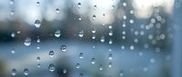 Water droplets on glass window with blurred background creating peaceful rainy day atmosphere for relaxation and mindfulness concepts.