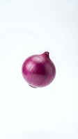 Fresh red onion with papery skin isolated on white background, suitable for food photography, culinary websites, and recipe illustrations.