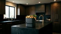 Modern luxury kitchen interior with dark cabinets, black countertops, brass fixtures and fresh flowers creating elegant contemporary home design atmosphere.