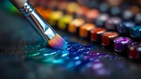 Artistic paintbrush dipping into vibrant watercolor paints with scattered pigments creating rainbow spectrum on dark surface, macro photography with selective focus.