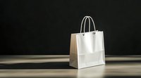 White paper shopping bag with handles on wooden surface against dark background for retail and commercial use.
