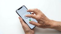 Close-up of mature male hands holding smartphone with blank screen, displaying technology usage and mobile device interaction for seniors and elderly users.