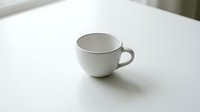 White ceramic coffee cup on clean table surface for morning beverage and cafe branding concepts.