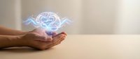 Hands cupping glowing heart with wings hologram representing love, care, protection and spiritual energy in healthcare and wellness concepts.
