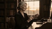 Mature Caucasian businesswoman working at vintage wooden desk in elegant office with warm sunset lighting through window creating professional atmosphere.