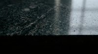 Dark granite countertop surface with natural stone texture and polished finish for modern kitchen and bathroom interior design applications.